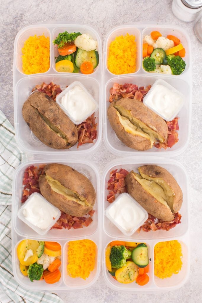 baked potatoes in lunchboxes with cheese, bacon and mixed veggies