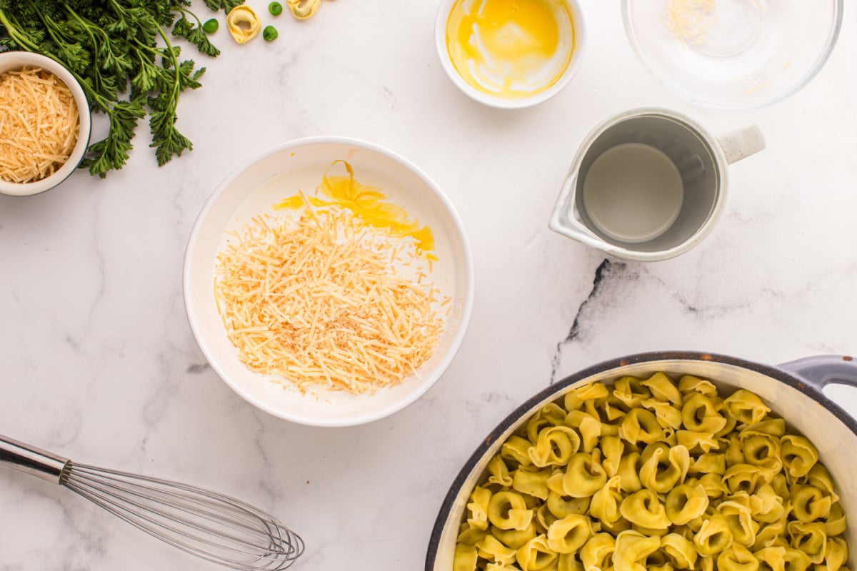 Heavy cream in a bowl, egg yolk and parmesan