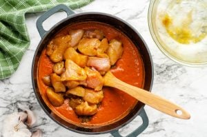 adding diced chicken to pan with sauce
