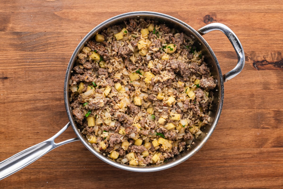 Add cooked rice, apples, garlic, sage and thyme to the pot