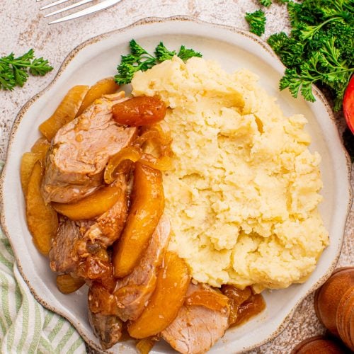 Slow cooker apple pie pork tenderloin on a plate with mashed potatoes