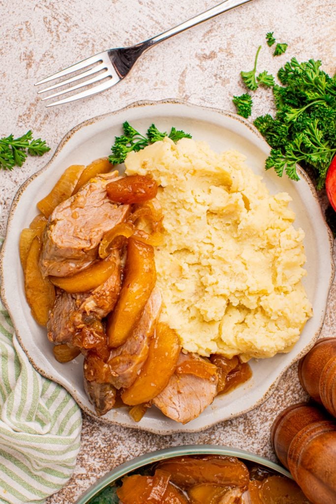 Slow cooker apple pie pork tenderloin on a plate with mashed potatoes