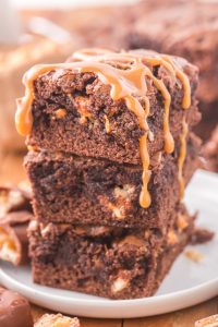 Snickers Brownies stacked on a plate