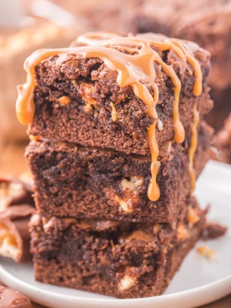 Snickers Brownies stacked on a plate