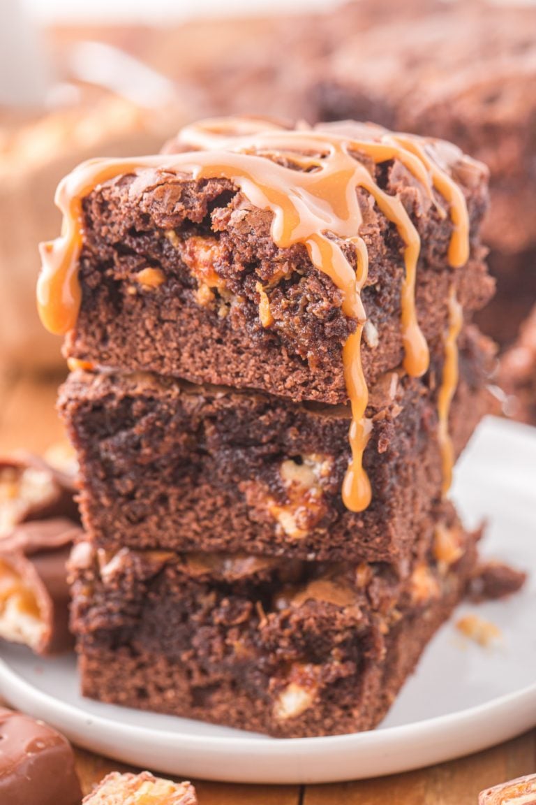 Snickers Brownies stacked on a plate