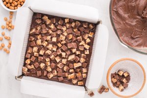 snicker bar pieces added to pan