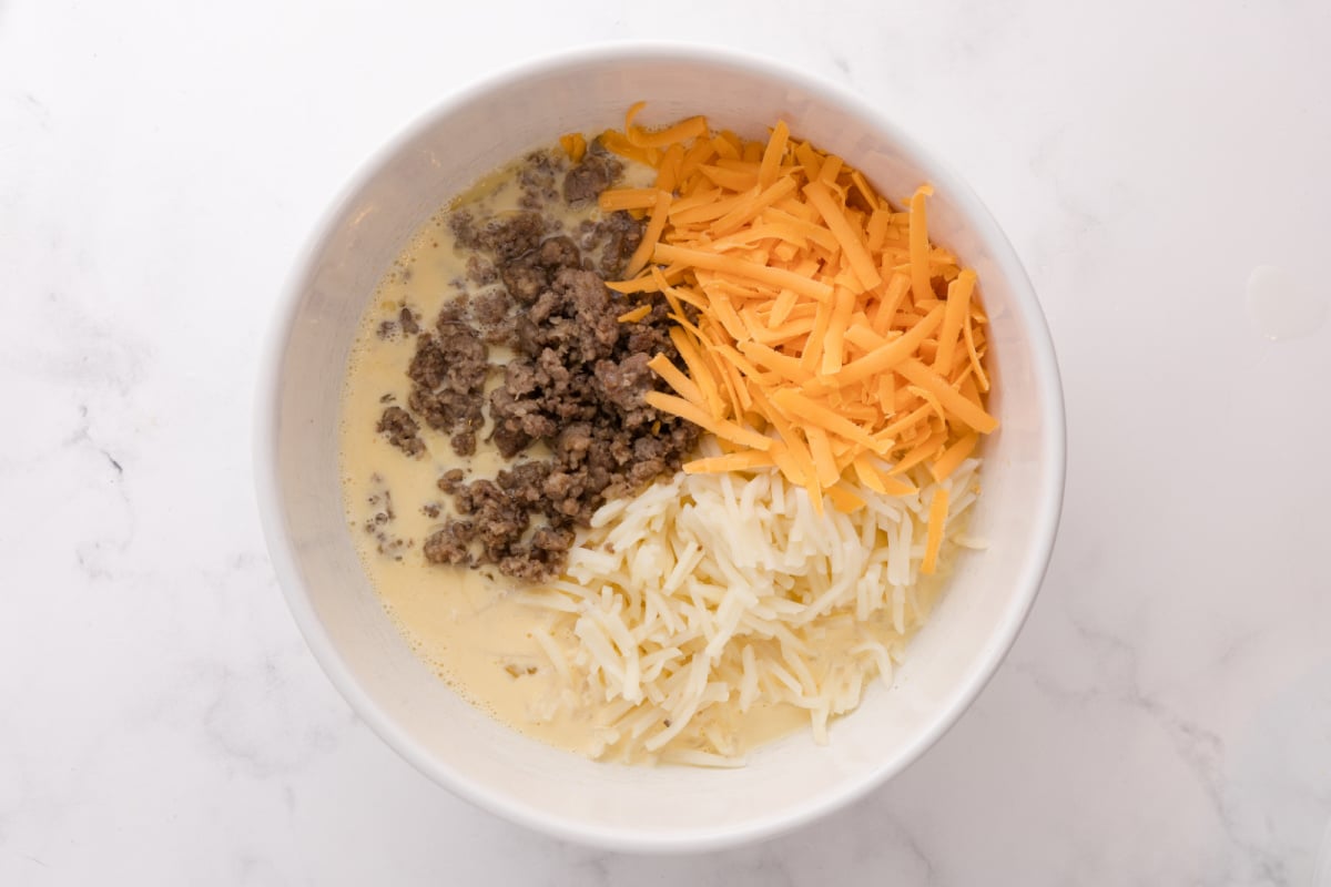 Add hash browns, cooked sausage, and 3/4 cup cheddar cheese to egg mixture