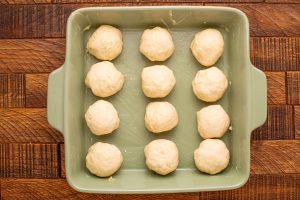 12 dough balls in a greased baking dish