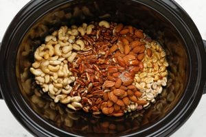mixed nuts and egg white mixture in a slow cooker