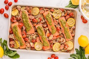vegetable mix added to sheet pan with salmon