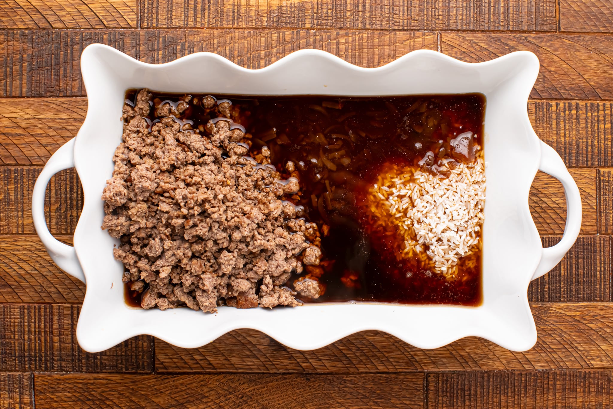 Add rice, cooked beef, broth and seasonings to baking dish