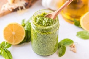homemade pesto in a jar with a wooden spoon