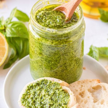 homemade pesto in a jar and spread on a piece of bread