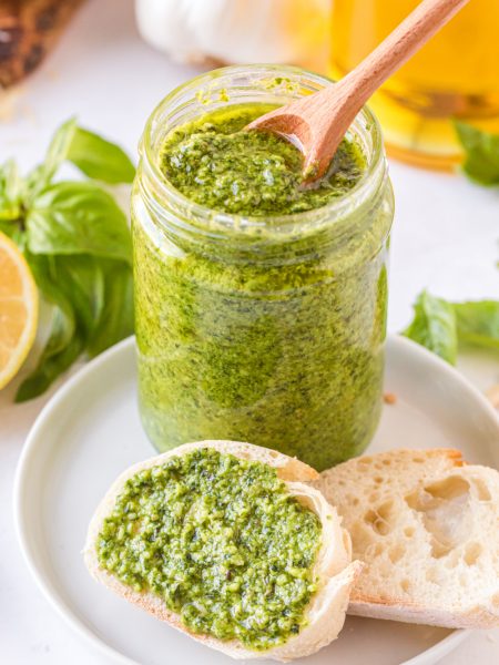 homemade pesto in a jar and spread on a piece of bread