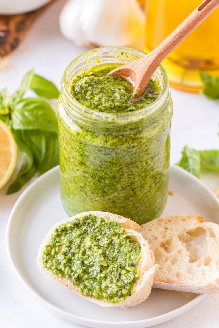 homemade pesto in a jar and spread on a piece of bread