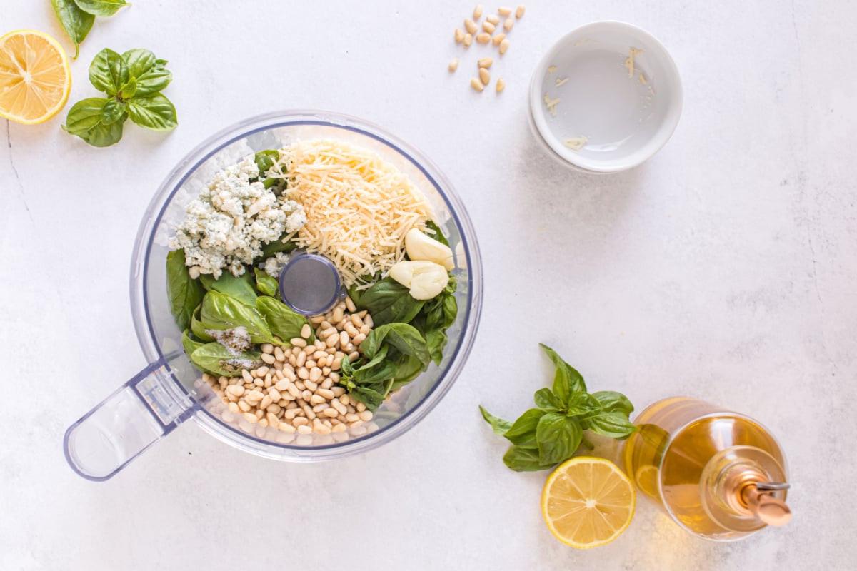 Place fresh basil, Parmesan cheese, toasted pine nuts, blue cheese, lemon juice, salt, pepper and oregano in a food processor