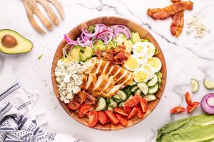 Sliced chicken and bacon added to the bowl