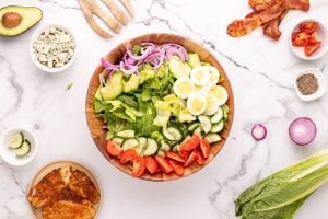 avocado, cucumber, tomato, egg, onion added to bowl