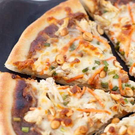 Thai Chicken Pizza sliced on a plate