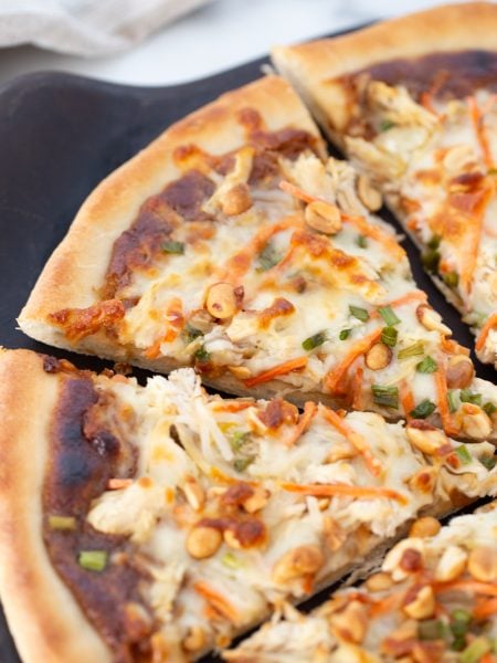 Thai Chicken Pizza sliced on a plate