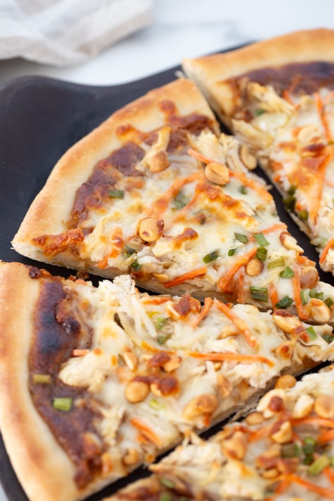 Thai chicken pizza slices on plate