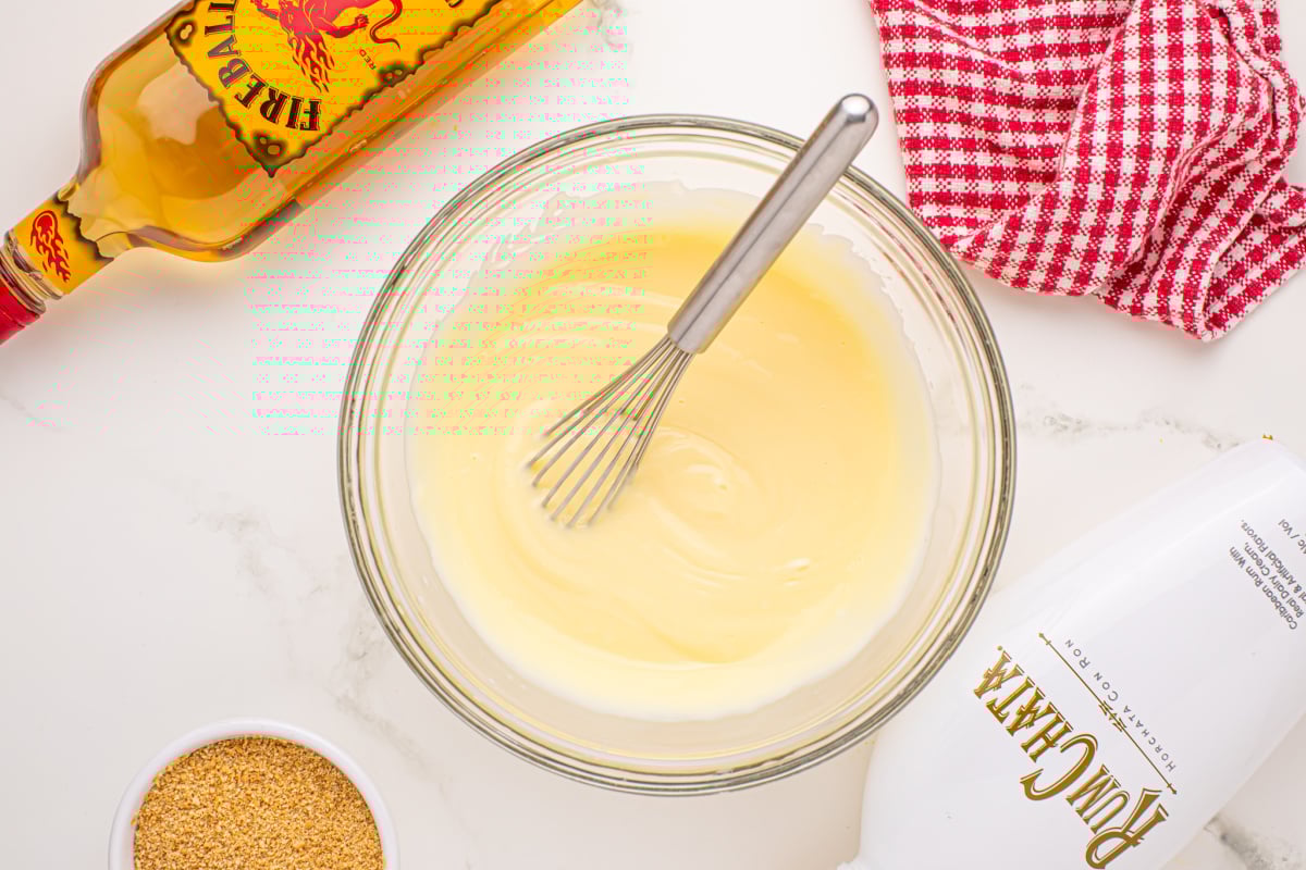 Combine cold milk, RumChata and Fireball with cheesecake pudding in bowl