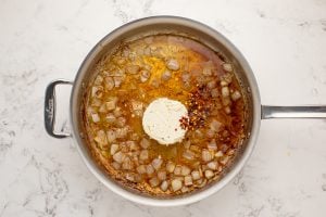 Boursin cheese and chili flakes added to pan