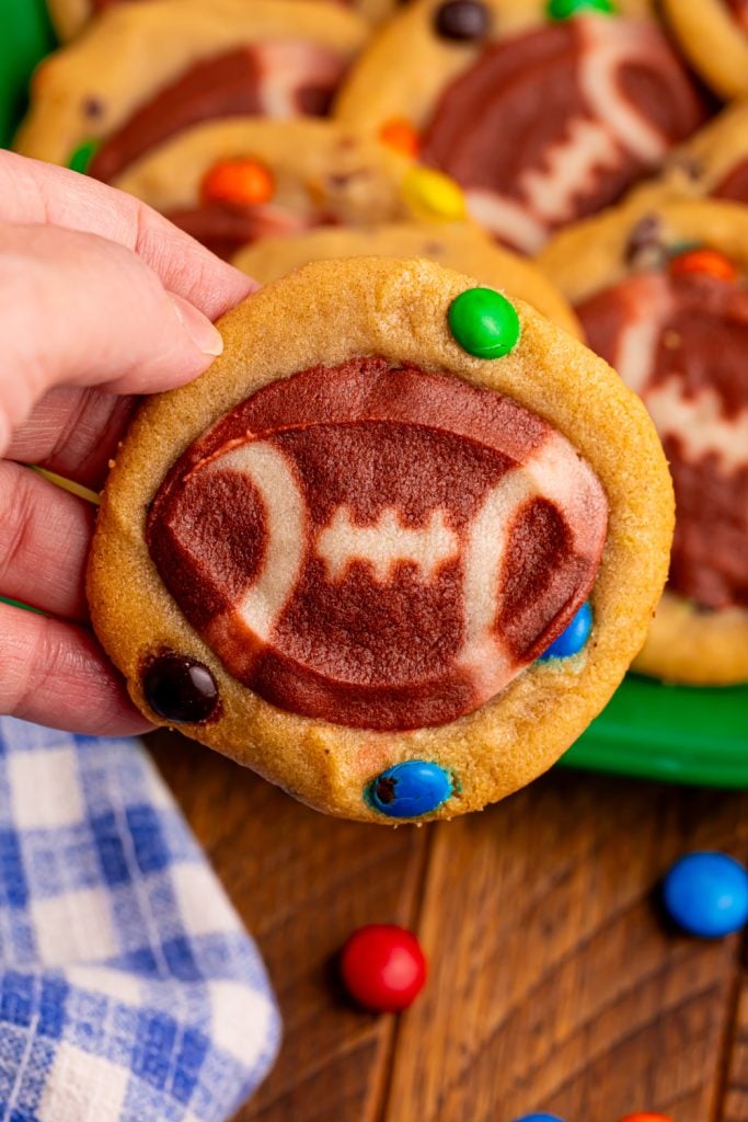 Hand holding football cookie