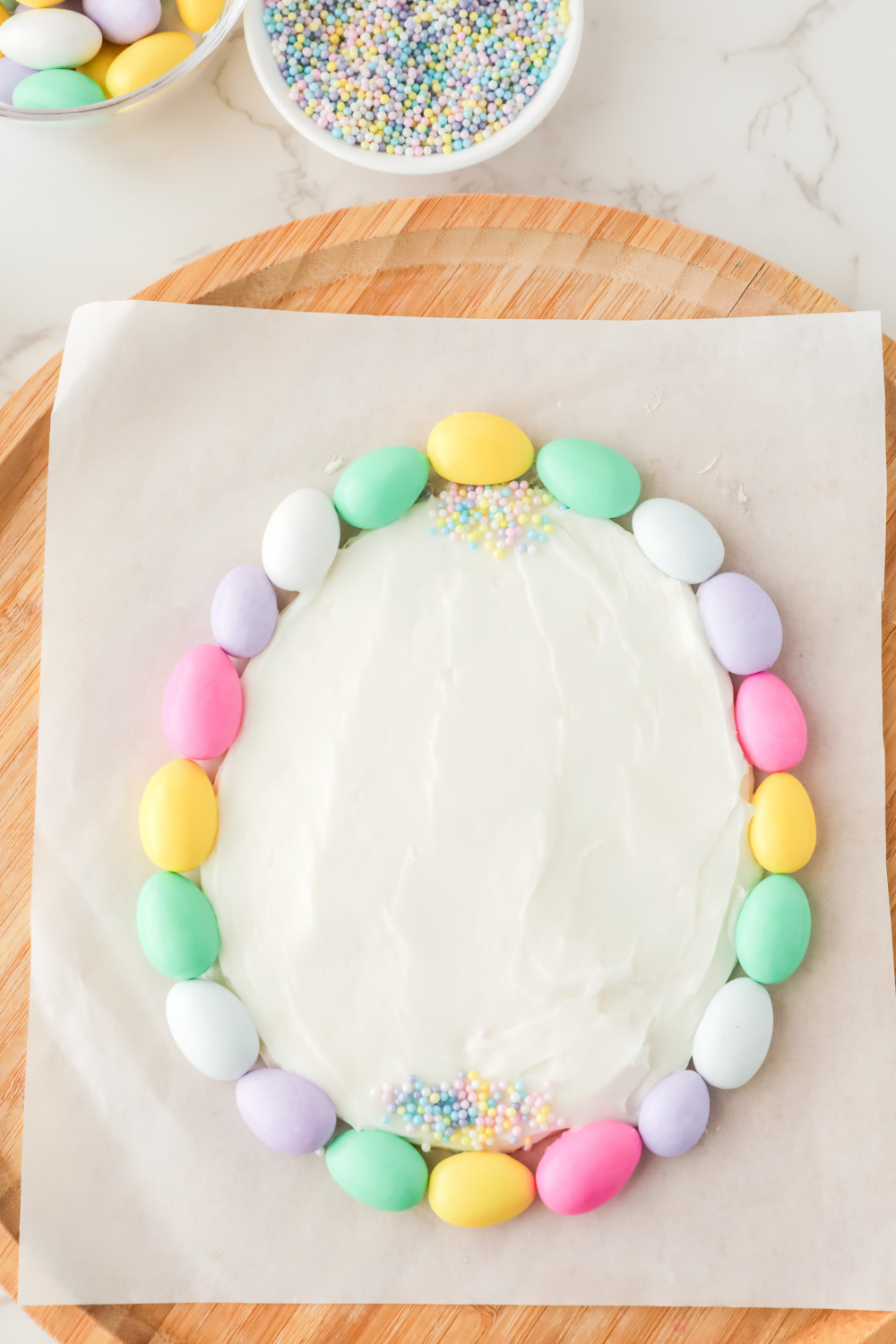 Add powdered sugar and confectioners almonds to frosting shaped eggs