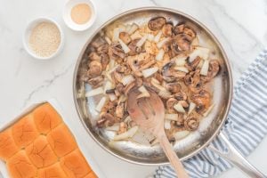 mushrooms and onions cooking in a pan
