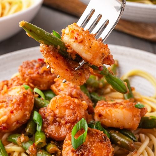 Place chili crispy shrimp on plate with fork