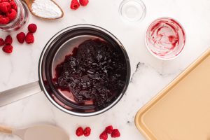 raspberry jam, water and almond extract in a medium sized saucepan