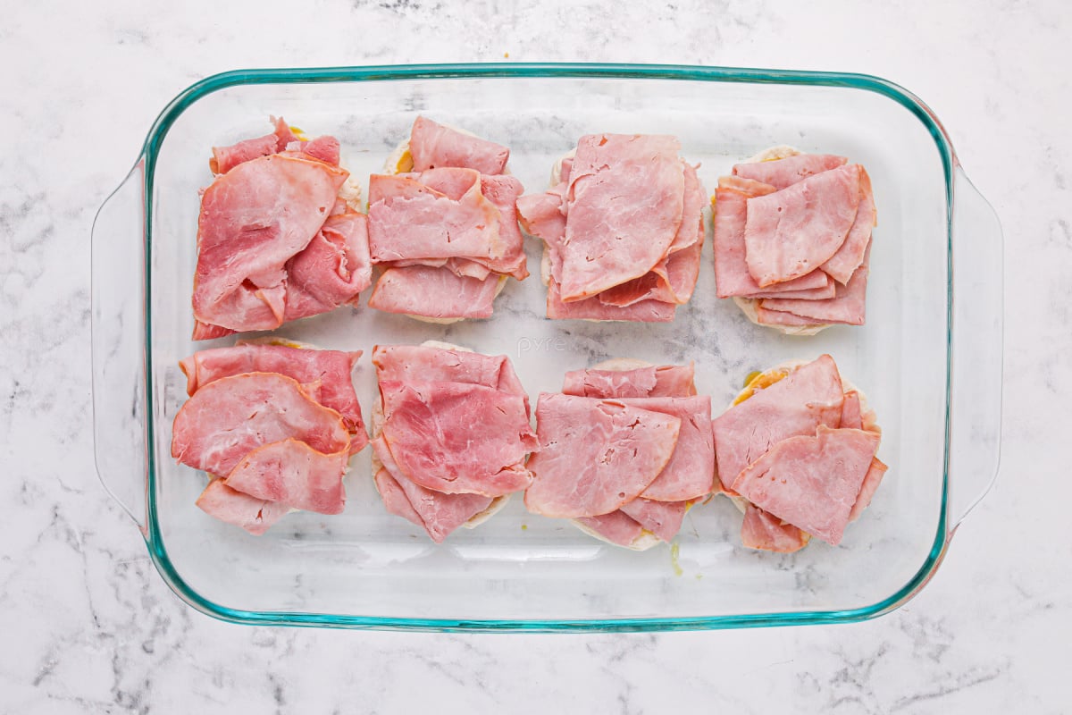 Place sliced ​​ham on biscuits