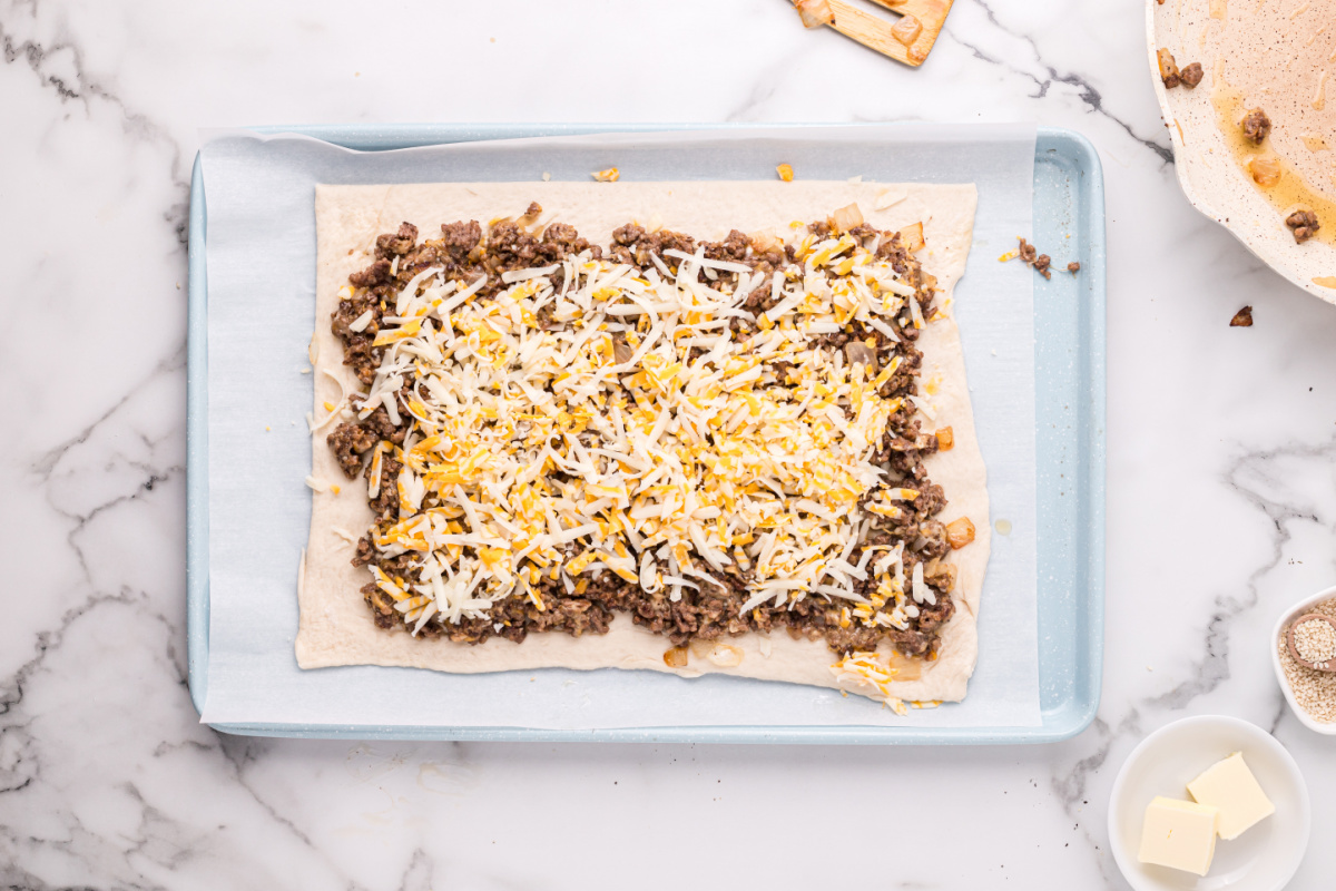 meat mixture and cheese spread on dough
