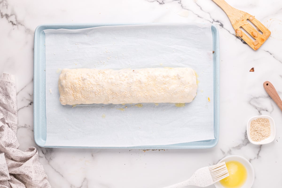 butter and sesame seeds added to top of roll