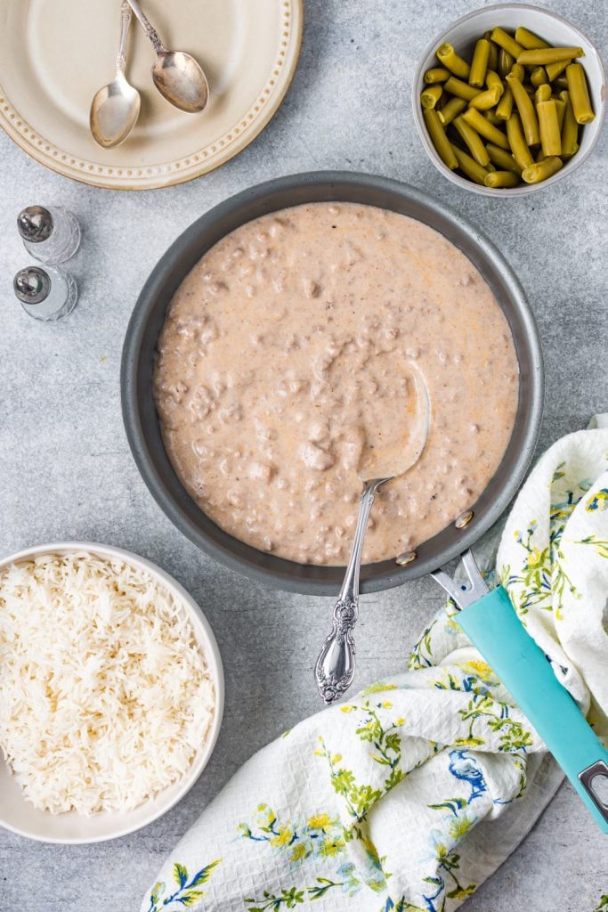 Easy Beef Hamburger Gravy in a pan and a bowl of rice and bowl of green beans