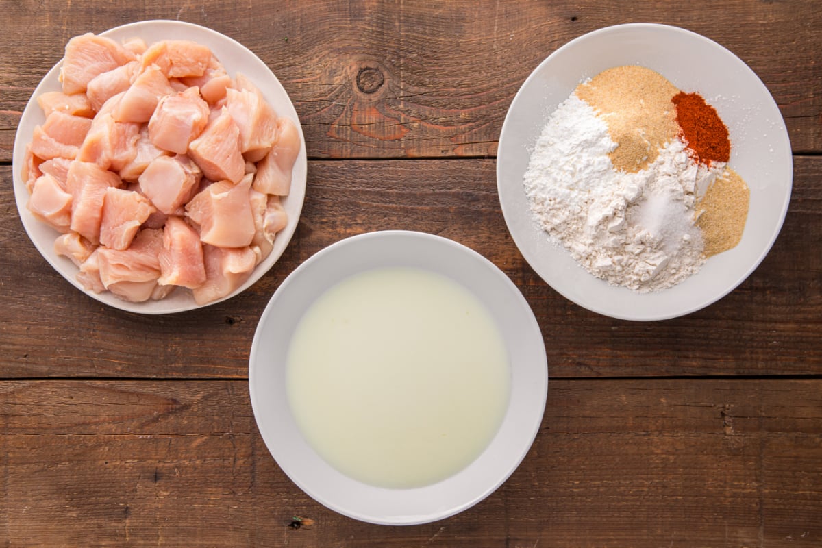 chicken pieces, seasoning and milk mixture in 3 different bowls