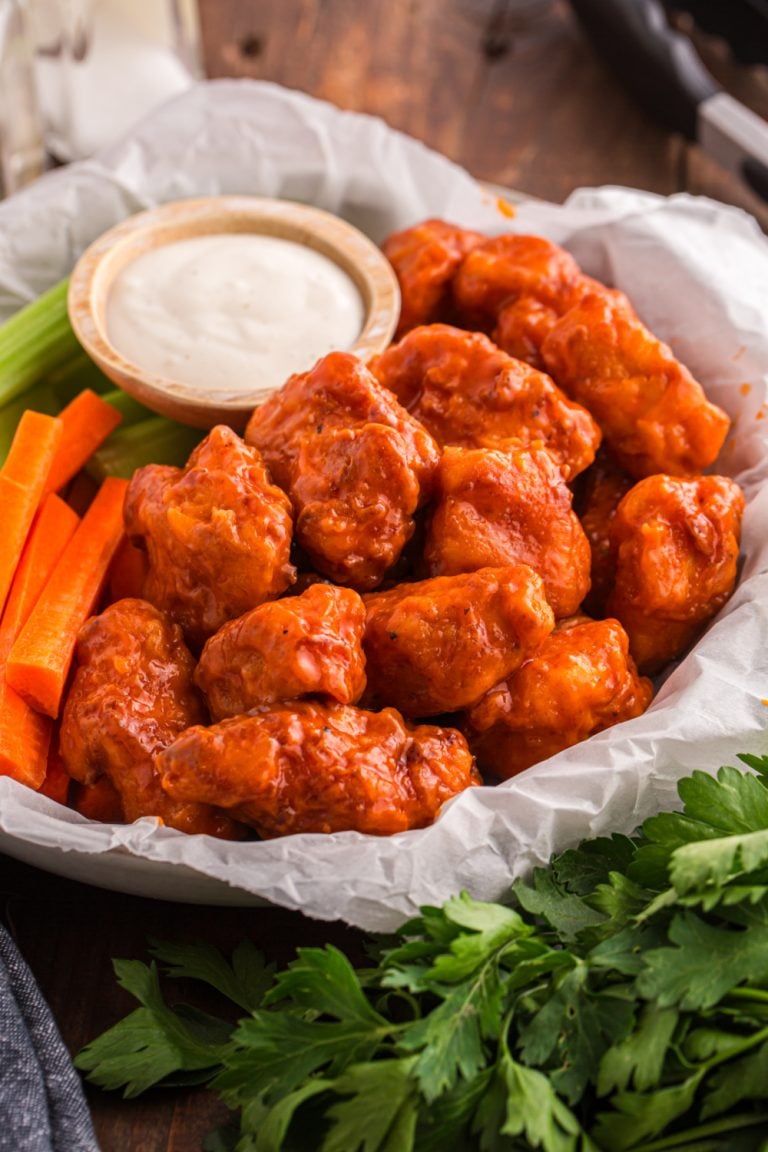 Homemade Crispy Boneless Chicken Wings in a basket with sauce, celery and carrots