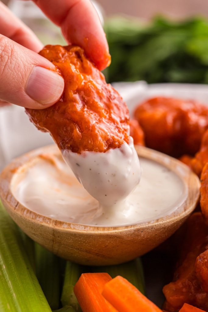 Homemade Crispy Boneless Chicken Wings being dipped in ranch