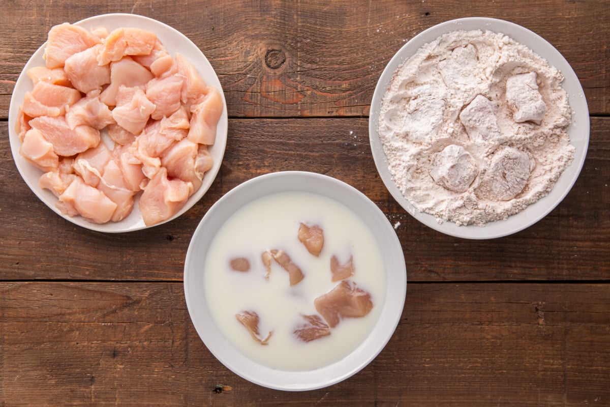 chicken being dipped in to mixtures