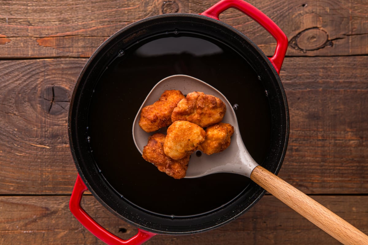 removing chicken with slotted spoon