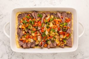 sauteed pepper and onions placed on top of roast beef