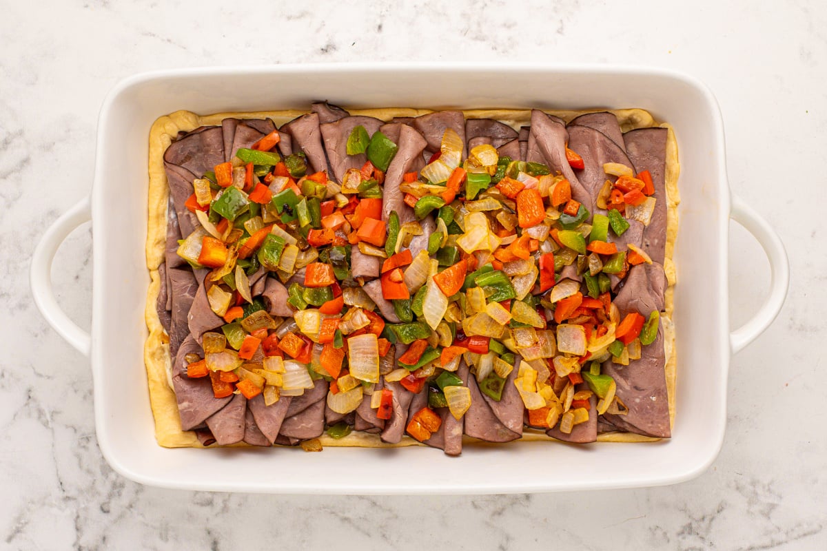 sauteed pepper and onions placed on top of roast beef