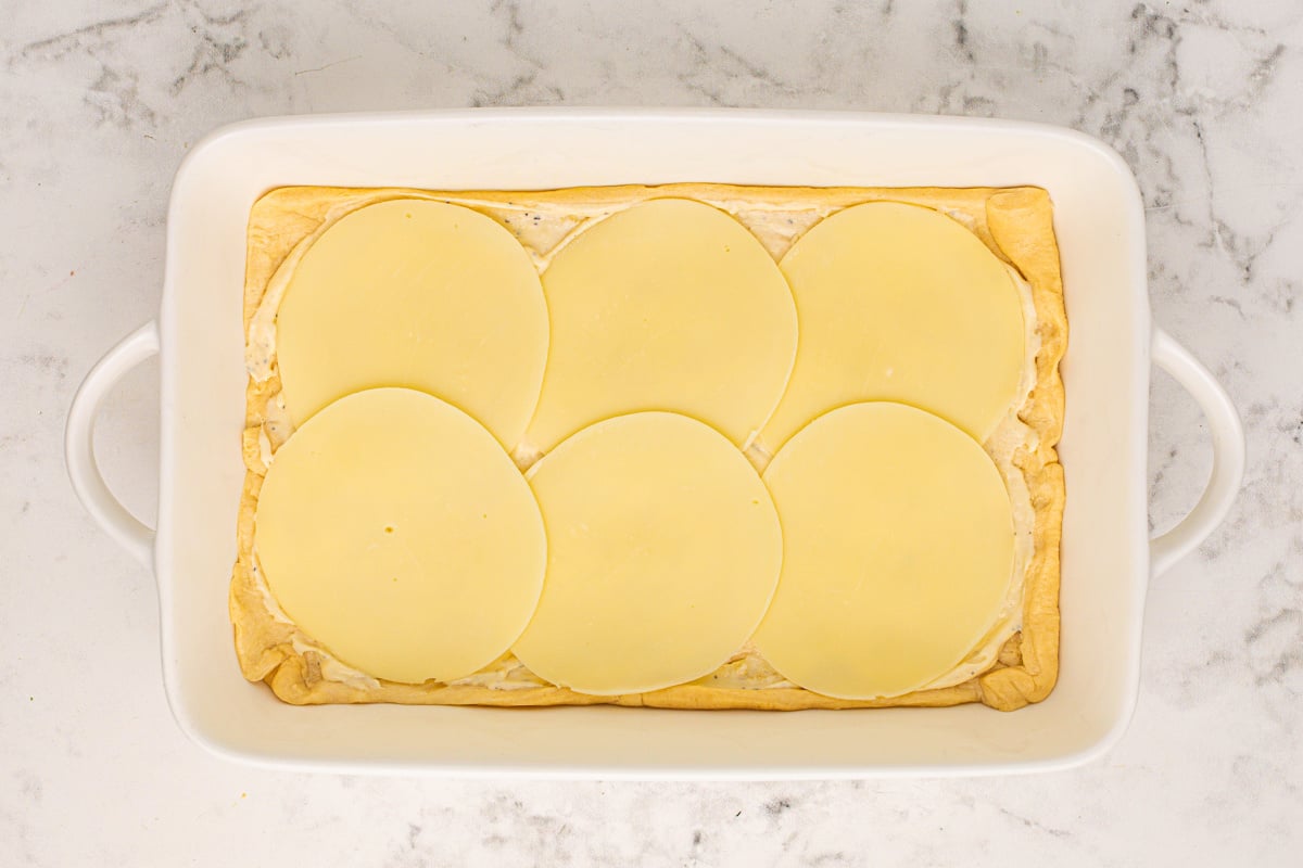 6 slices of provolone cheese placed on top of crescent roll