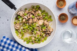 onion, bell pepper and mushrooms in a pan