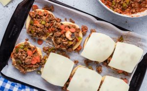 meat mixture placed on buns and topped with slice of cheese
