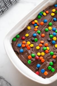 brownie batter and m&ms placed on top of the batter