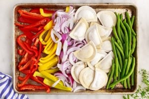 frozen pierogi, and veggies on a sheet pan