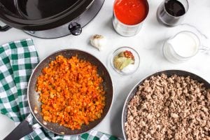 cooked meat in a pan and cooked veggies in a pan