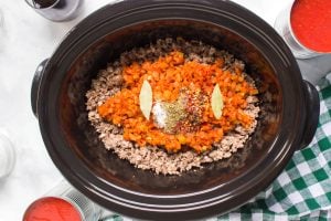 meat mixture, veggies mixture, seasonings and bay leaves in a slow cooker